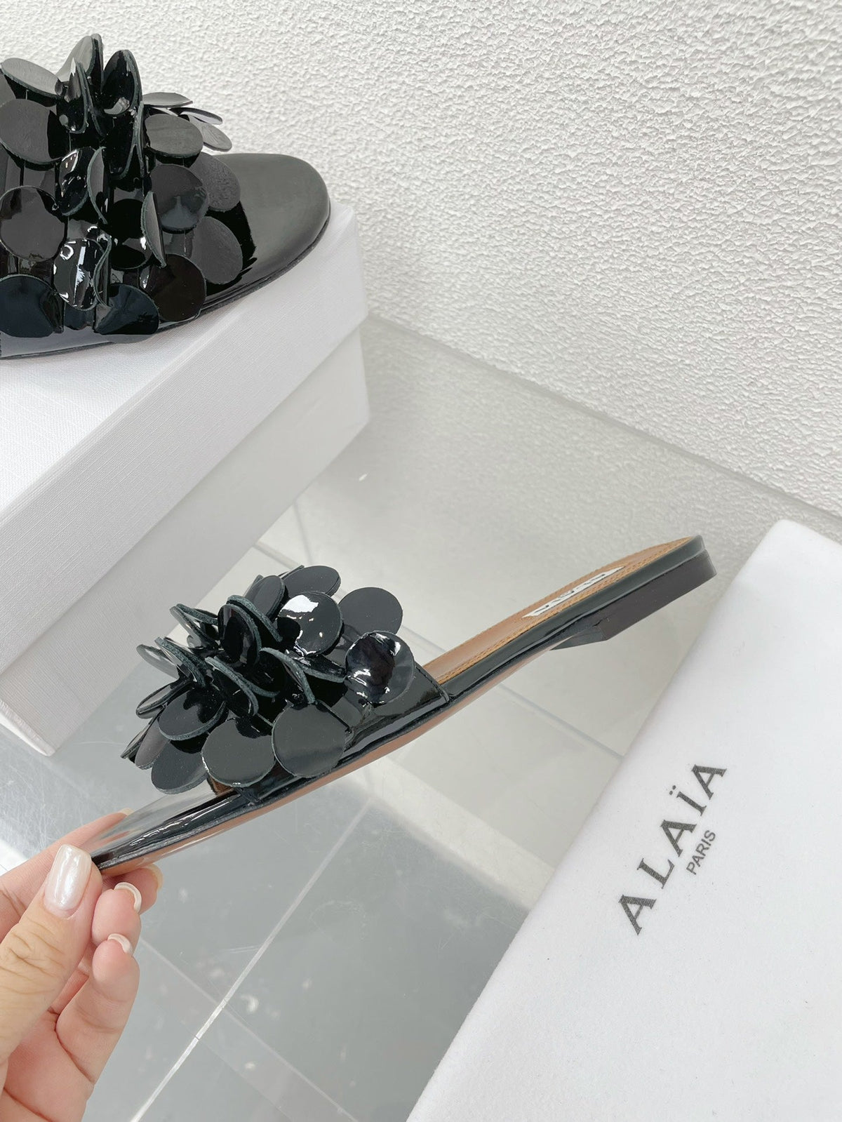 ALAIA FLAT MULE IN BLACK GLOSSY LAMBSKIN
