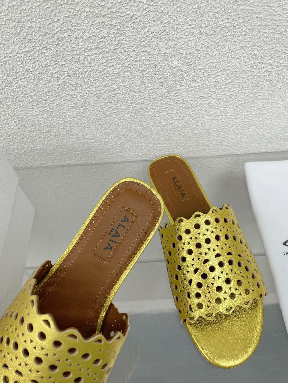 ALAIA VIENNE FLAT MULES IN GOLDEN LAMBSKIN
