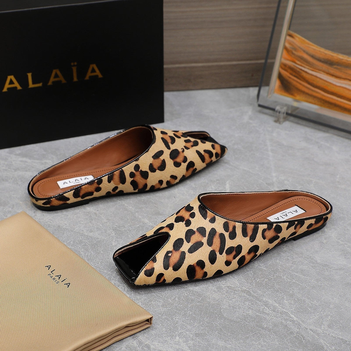ALAIA FLAT MULE IN LEOPARD LAMBSKIN