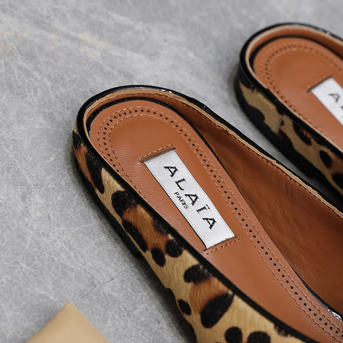 ALAIA FLAT MULE IN LEOPARD LAMBSKIN