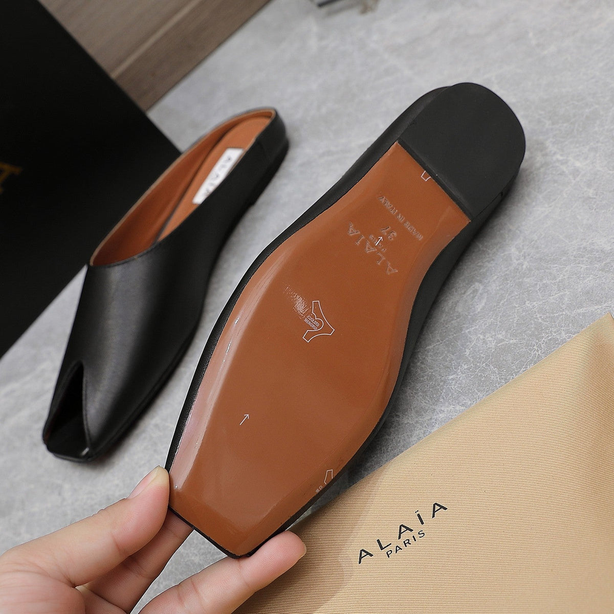 ALAIA FLAT MULE IN BLACK LAMBSKIN