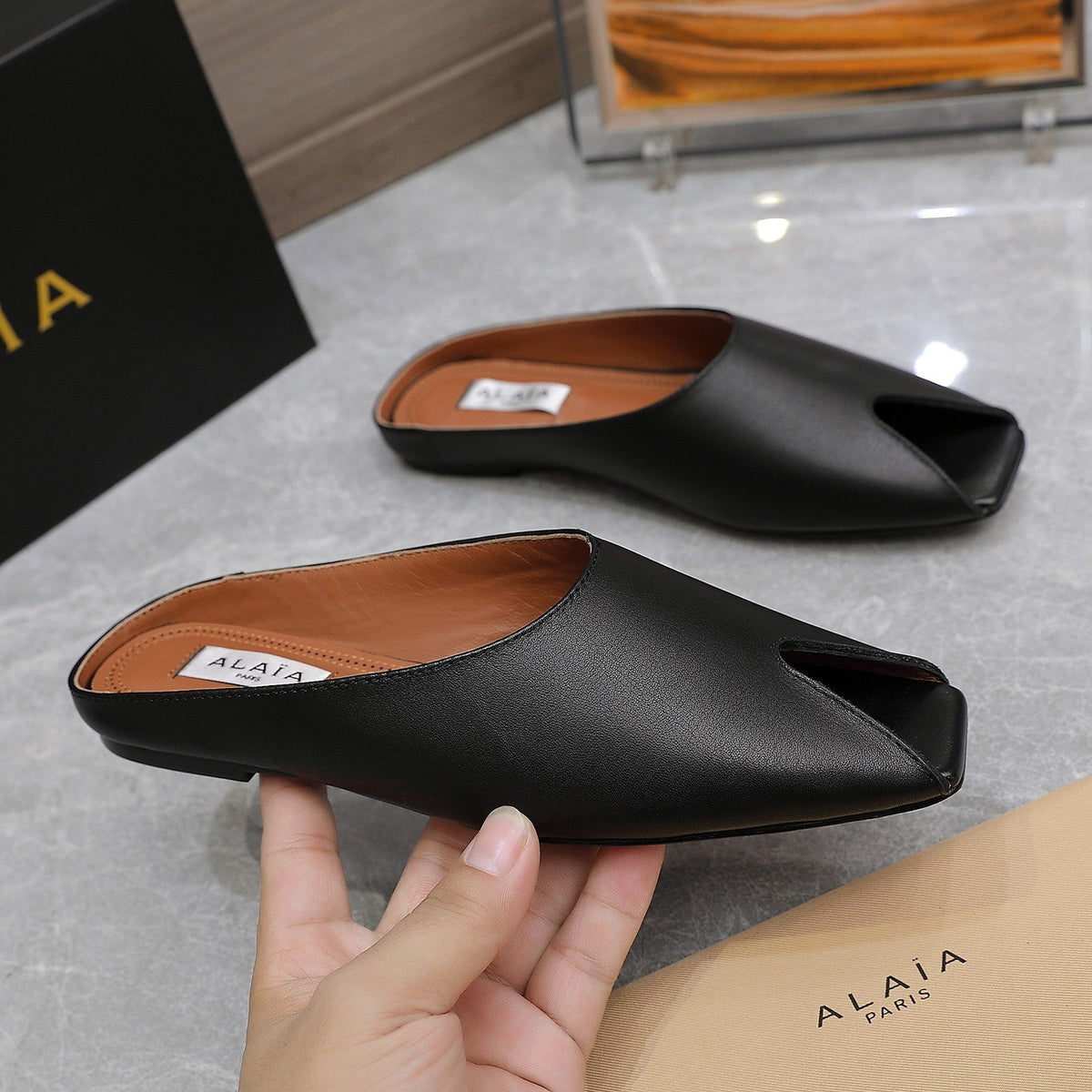 ALAIA FLAT MULE IN BLACK LAMBSKIN