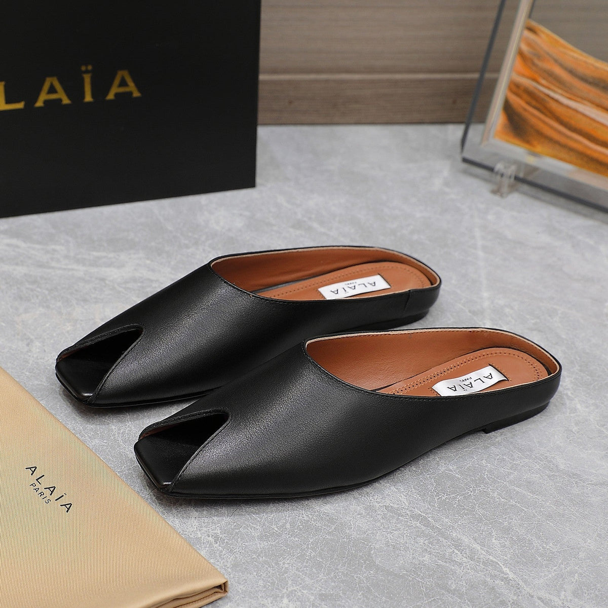 ALAIA FLAT MULE IN BLACK LAMBSKIN