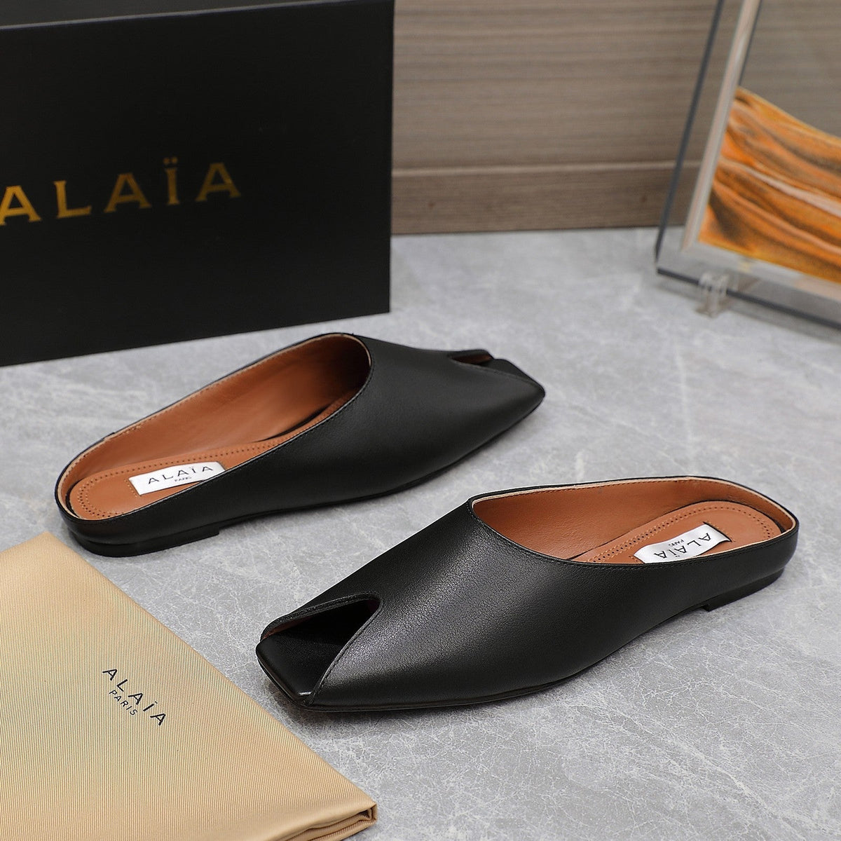 ALAIA FLAT MULE IN BLACK LAMBSKIN
