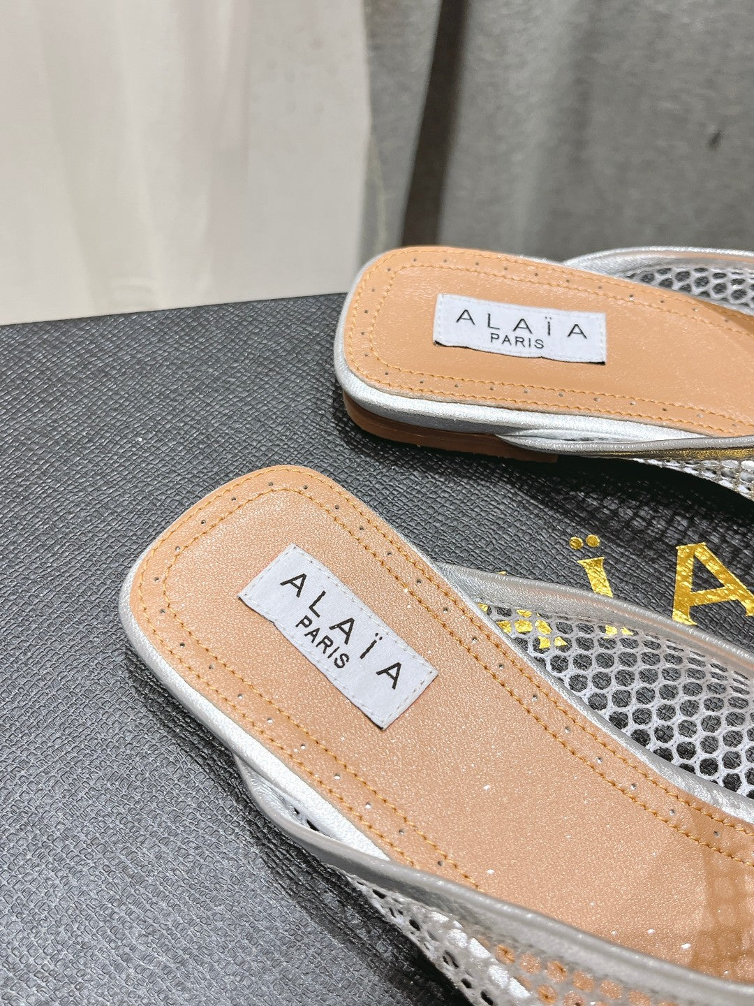 ALAIA FLAT MULES IN SILVER MESH FISHNET