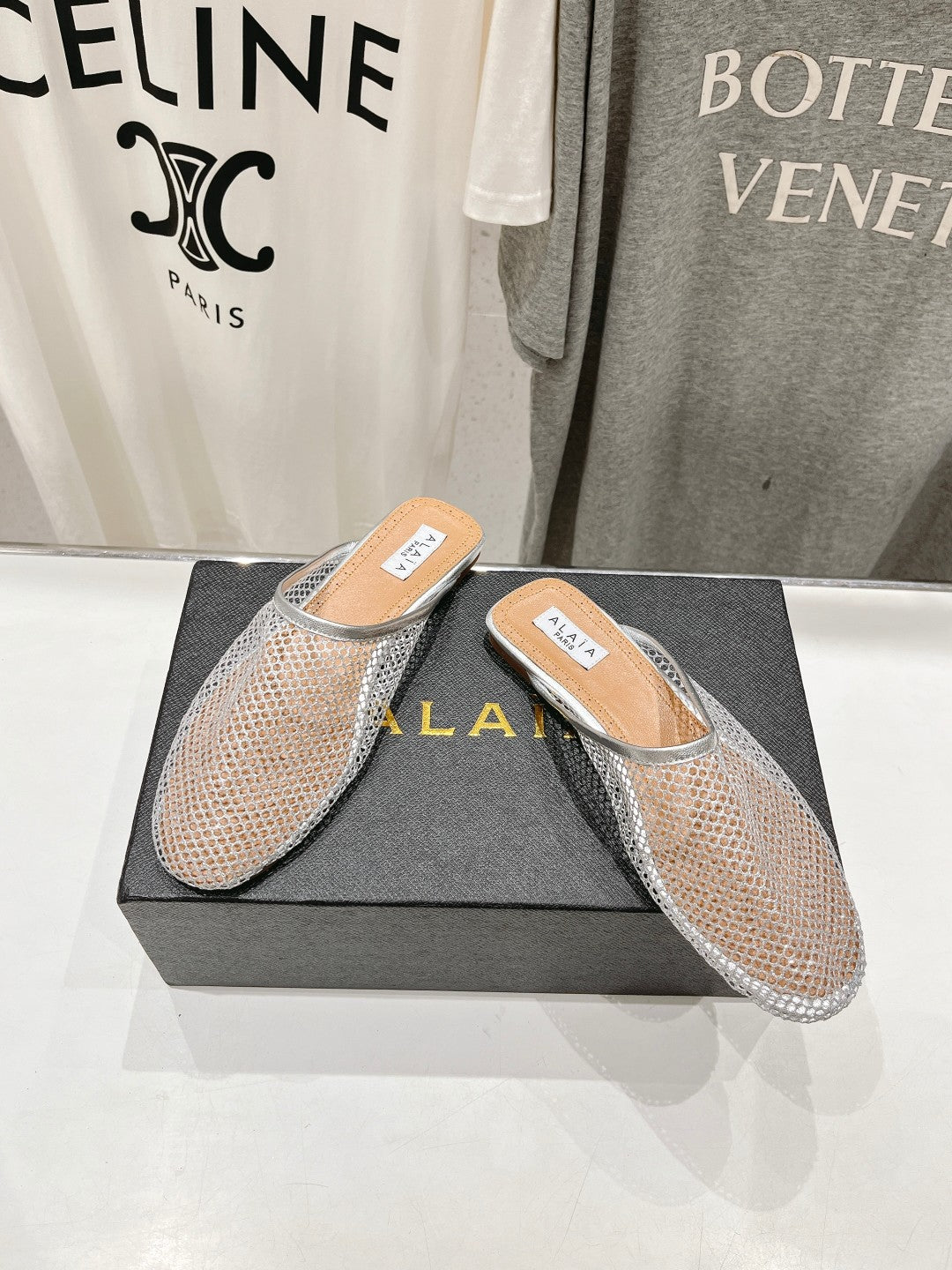 ALAIA FLAT MULES IN SILVER MESH FISHNET